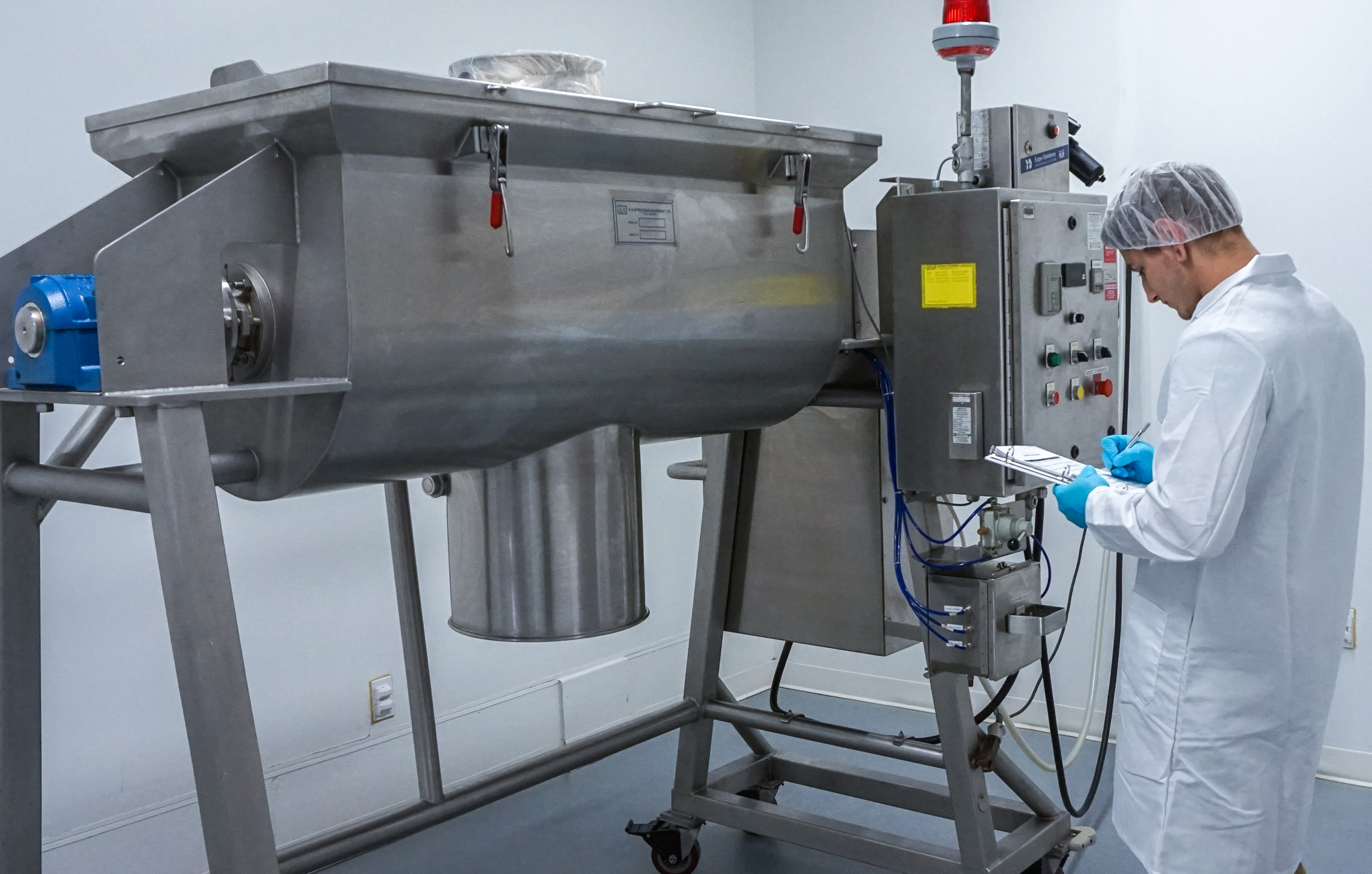 A worker manufactures a custom supplement order in our contract manufacturing facility